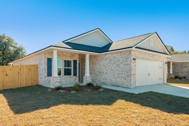 view of front of house featuring an attached garage, fence, driveway, roof with shingles, and a front yard