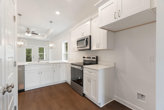 kitchen with white cabinetry, a sink, stainless steel appliances, light countertops, and dark wood-style floors