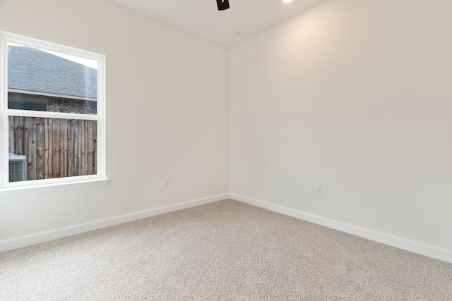 carpeted empty room with a ceiling fan and baseboards