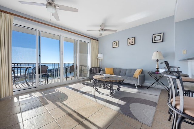 living area featuring a water view, a ceiling fan, and tile patterned floors