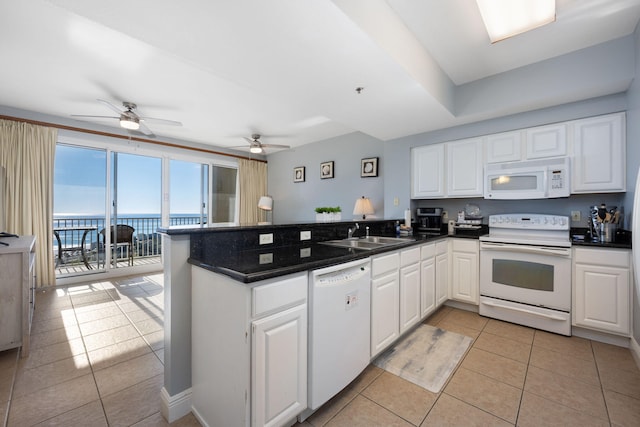 kitchen featuring white appliances, a water view, a peninsula, and white cabinets