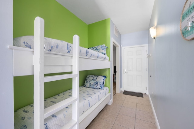 bedroom with baseboards and light tile patterned floors