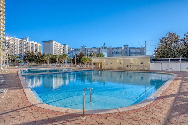 community pool featuring fence and a city view