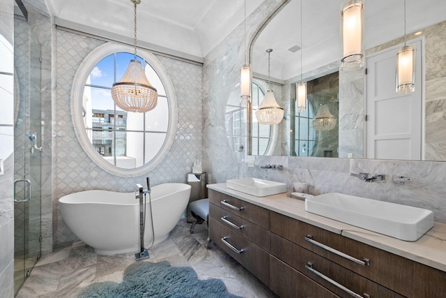 bathroom featuring a freestanding bath, marble finish floor, a sink, and a shower stall