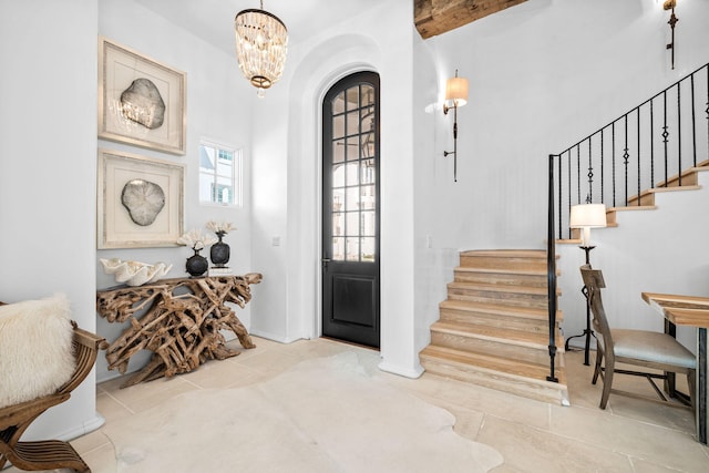 tiled entrance foyer featuring stairs and a notable chandelier