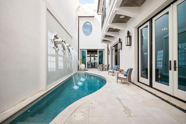 view of swimming pool featuring a patio and french doors