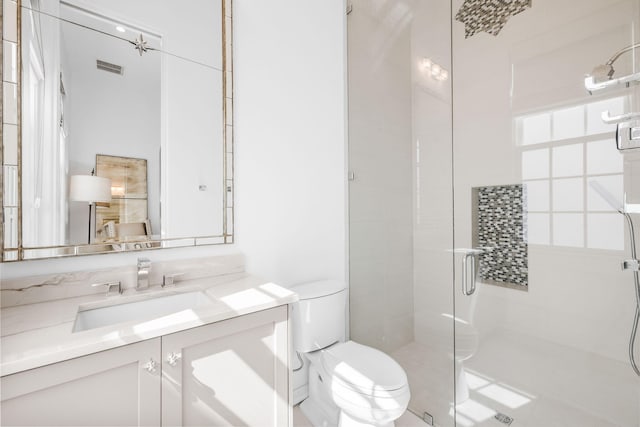 bathroom featuring visible vents, a stall shower, vanity, and toilet