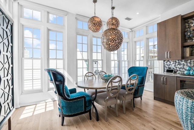 dining room with light wood-style flooring, visible vents, and a chandelier