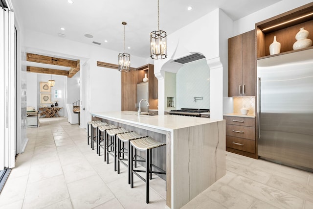 kitchen featuring stainless steel built in fridge, a sink, decorative backsplash, open shelves, and beamed ceiling