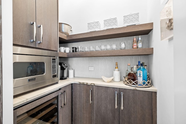 kitchen featuring wall oven, stainless steel microwave, light countertops, dark brown cabinets, and open shelves