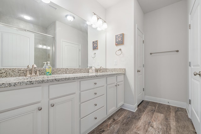 124 Conner Cir, Santa Rosa Beach, FL 32459 - full bathroom with double vanity, a stall shower, baseboards, wood finished floors, and a sink