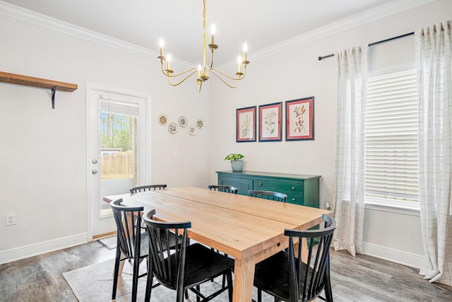 124 Conner Cir, Santa Rosa Beach, FL 32459 - dining space with an inviting chandelier, crown molding, baseboards, and wood finished floors