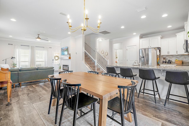 124 Conner Cir, Santa Rosa Beach, FL 32459 - dining space with light wood-style floors, stairs, crown molding, and recessed lighting