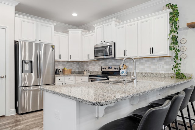 124 Conner Cir, Santa Rosa Beach, FL 32459 - kitchen featuring appliances with stainless steel finishes, white cabinets, a peninsula, and a breakfast bar area