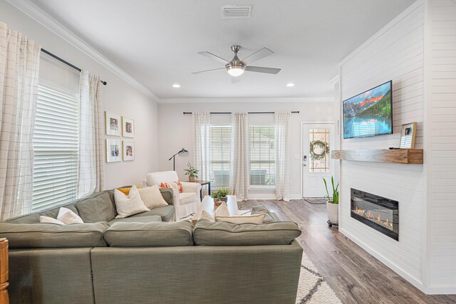124 Conner Cir, Santa Rosa Beach, FL 32459 - living area with wood finished floors, a glass covered fireplace, visible vents, and crown molding