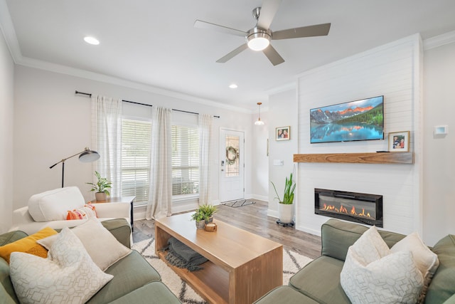 124 Conner Cir, Santa Rosa Beach, FL 32459 - living room with a large fireplace, a ceiling fan, baseboards, ornamental molding, and light wood-type flooring