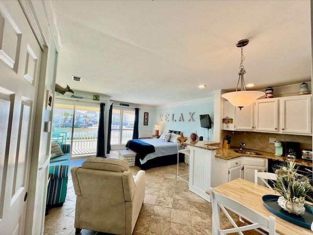 bedroom featuring crown molding, visible vents, stone finish flooring, a sink, and access to outside