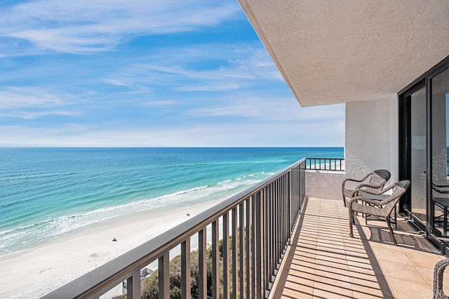 balcony featuring a water view and a beach view