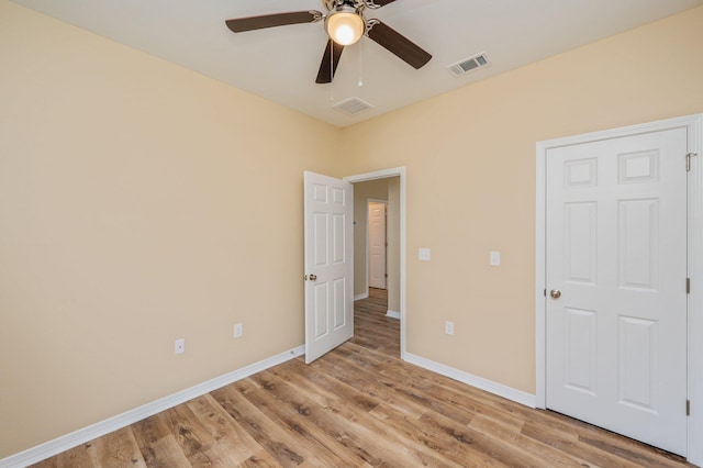 unfurnished bedroom with light wood-style floors, baseboards, visible vents, and a ceiling fan