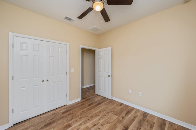 unfurnished bedroom with light wood-style flooring, a closet, visible vents, and baseboards