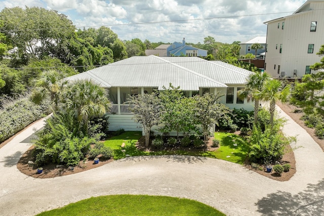 view of front of house with a front yard, metal roof, and driveway