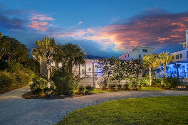 view of front of house featuring decorative driveway and a yard