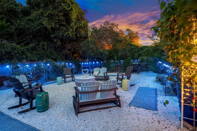 patio terrace at dusk with a fire pit and fence