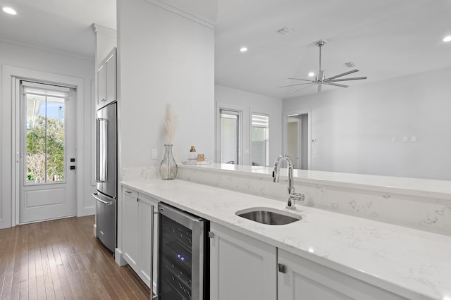 kitchen featuring dark wood-style flooring, white cabinetry, high quality fridge, a sink, and beverage cooler