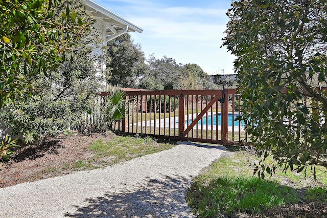 view of gate with a fenced in pool