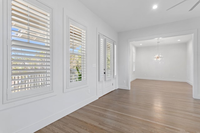 foyer featuring recessed lighting, wood finished floors, baseboards, and an inviting chandelier