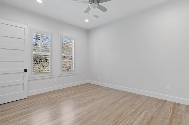 empty room featuring light wood finished floors, baseboards, and crown molding