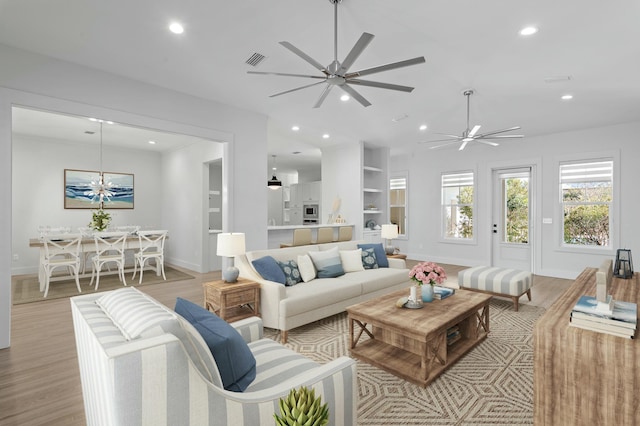 living area with light wood-type flooring, recessed lighting, and visible vents