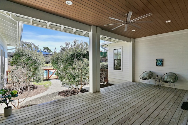 wooden terrace featuring fence and a ceiling fan