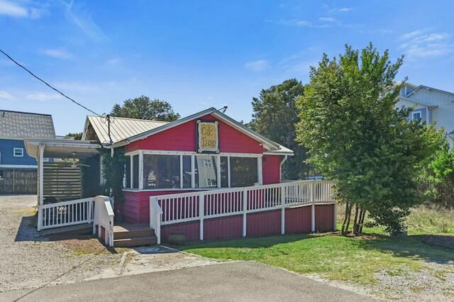 bungalow featuring a standing seam roof, a deck, metal roof, and a front yard