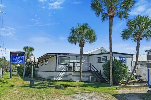 manufactured / mobile home with stairs and a front yard