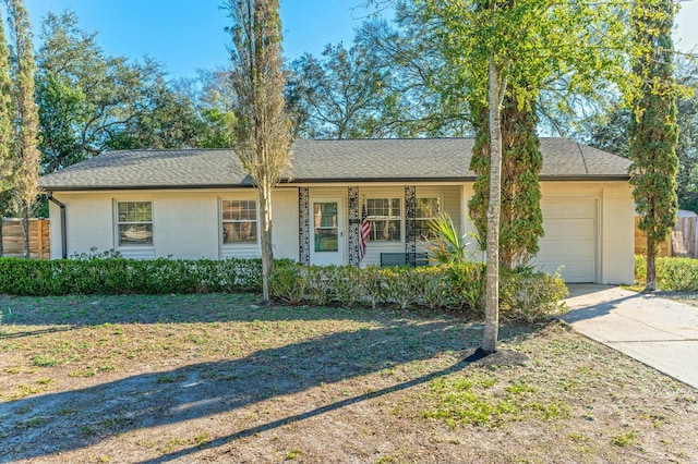 single story home featuring a garage, brick siding, roof with shingles, and a front lawn