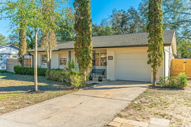 ranch-style house with a garage, driveway, brick siding, and roof with shingles