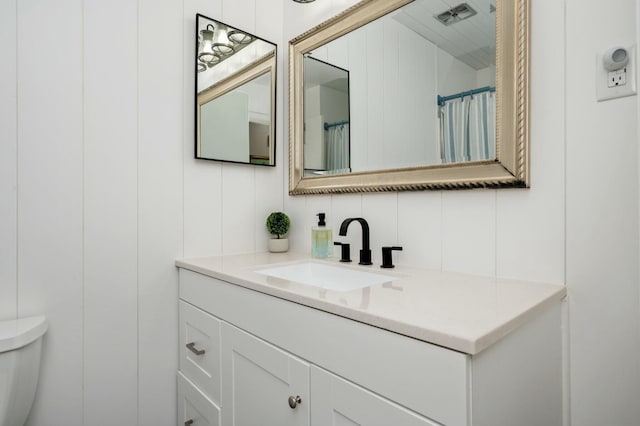 bathroom with visible vents, toilet, and vanity