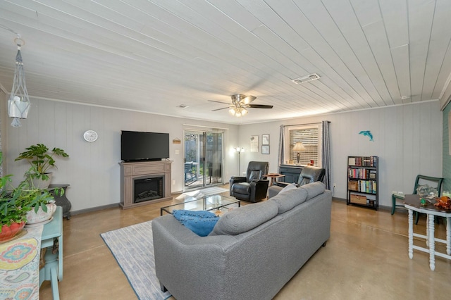 living room featuring concrete floors, visible vents, a fireplace, and ceiling fan