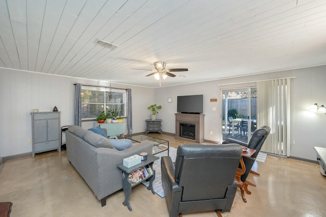 living room with finished concrete floors, visible vents, a fireplace, and baseboards