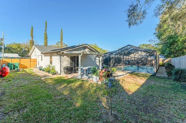 back of house with a yard, a patio, a lanai, and a fenced in pool