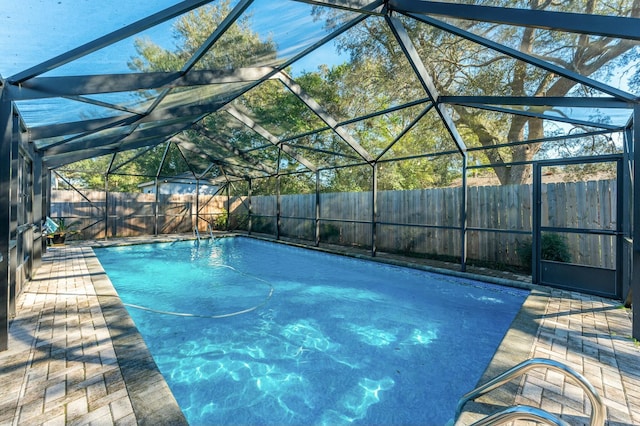 view of pool with a lanai and a fenced backyard