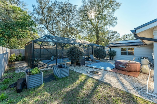 view of yard with a patio area, a hot tub, glass enclosure, and a fenced backyard