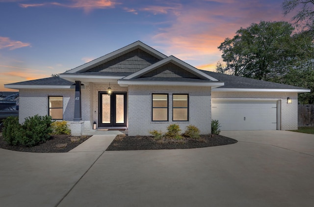 craftsman-style house with brick siding, driveway, and an attached garage