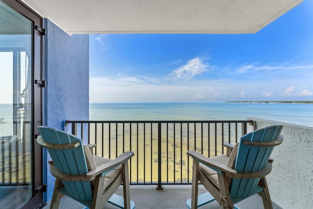 balcony with a water view and a beach view