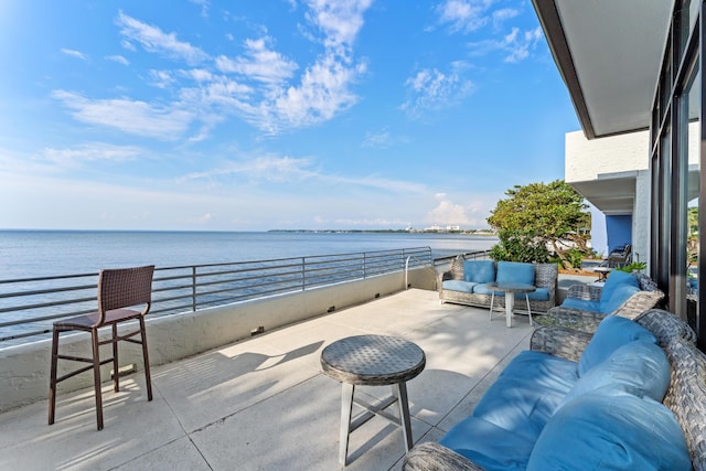 view of patio / terrace with a water view, a balcony, and an outdoor hangout area