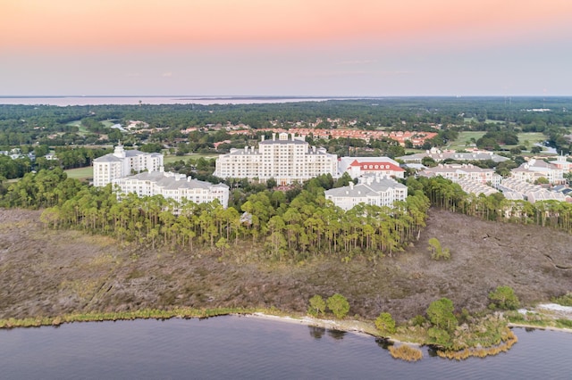 aerial view at dusk featuring a water view