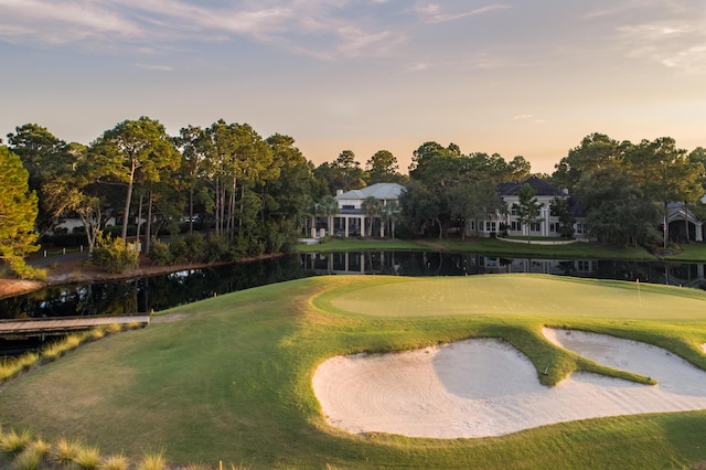 view of community featuring a yard, golf course view, and a water view