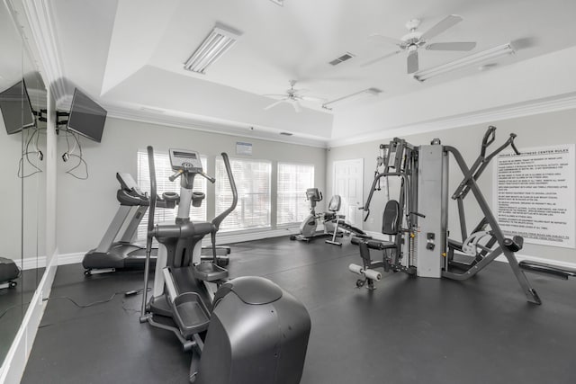 exercise room featuring visible vents, a tray ceiling, ceiling fan, and baseboards