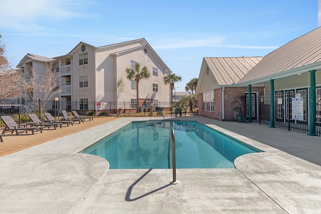 pool with a patio area and fence